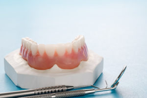 Close up , Complete denture or full denture on blue background.